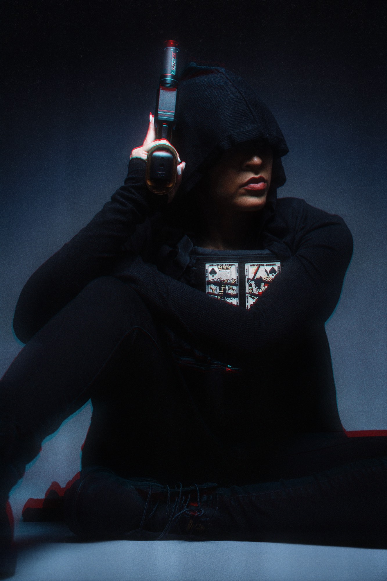 Walnette in black hood with pistol