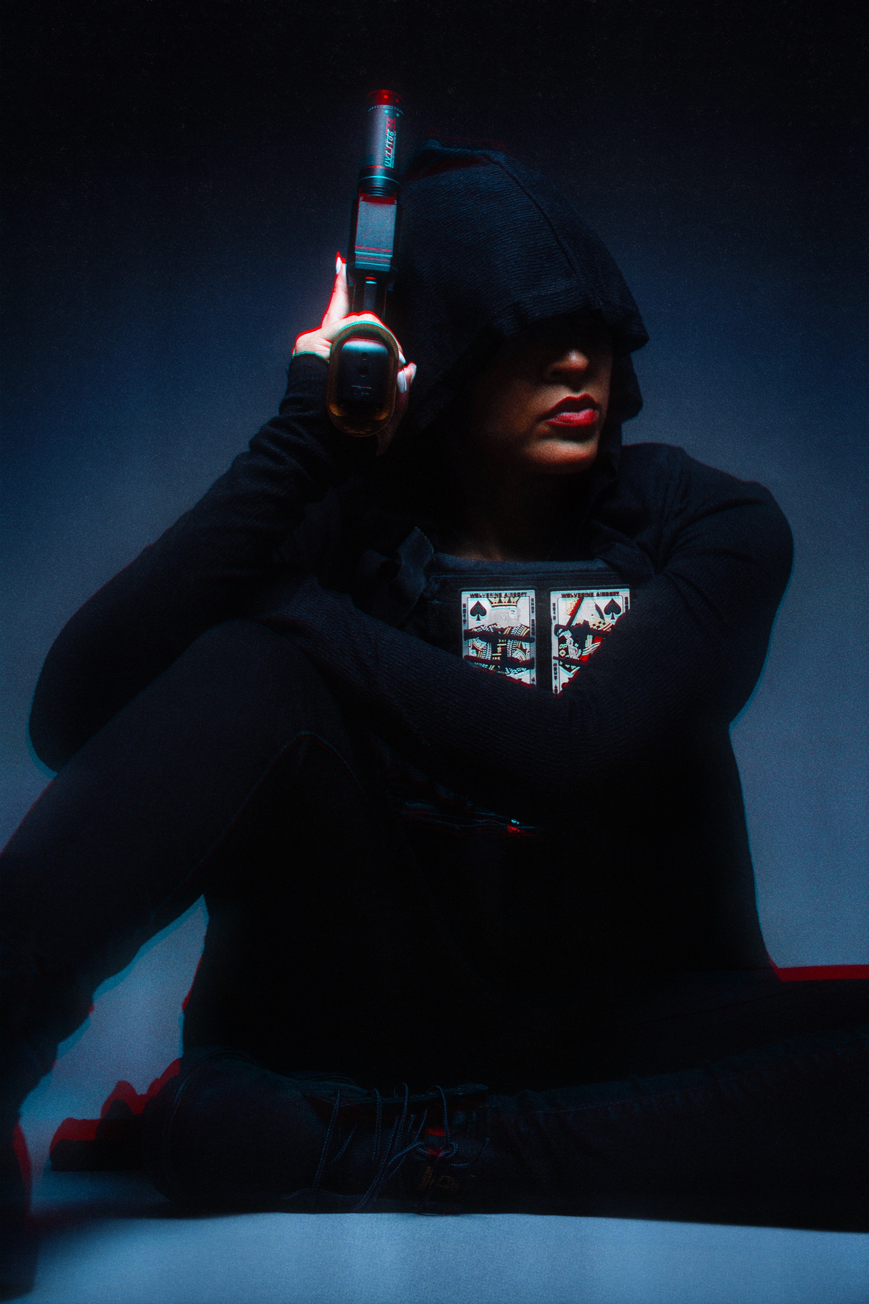 Walnette in black hood with pistol